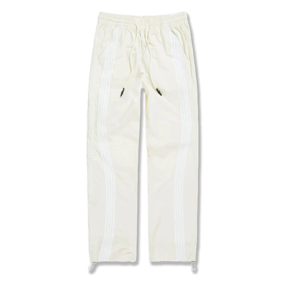 Cream Jordan Craig Big Men's The Beautiful Game track pants with white side stripes, drawstring waist, and water-resistant polyester.
